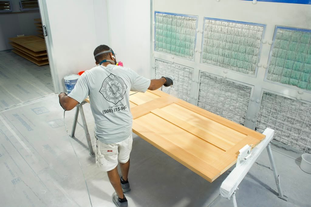 Cabinet doors being spray finished in Compass Painting's Hyannis finishing shop